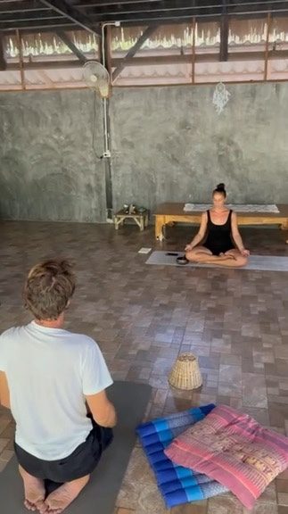 Cristal teaching a seated student in an open-air shala